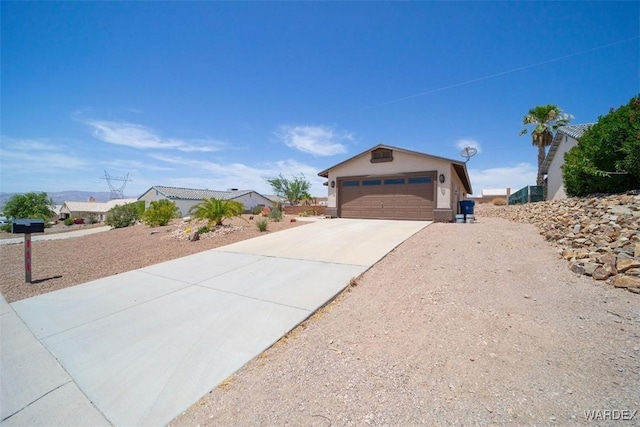 single story home with a garage, concrete driveway, and stucco siding