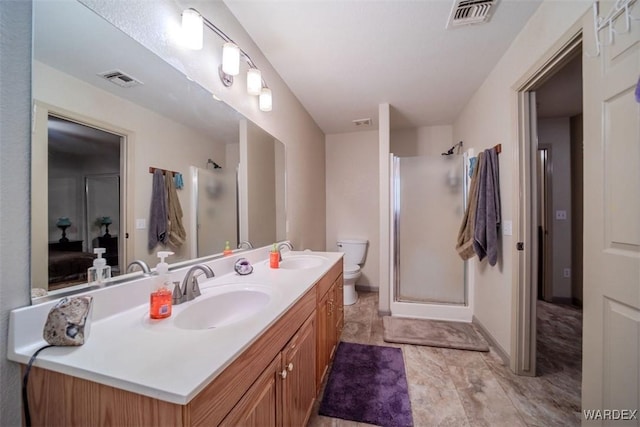 ensuite bathroom with a stall shower, visible vents, a sink, and double vanity