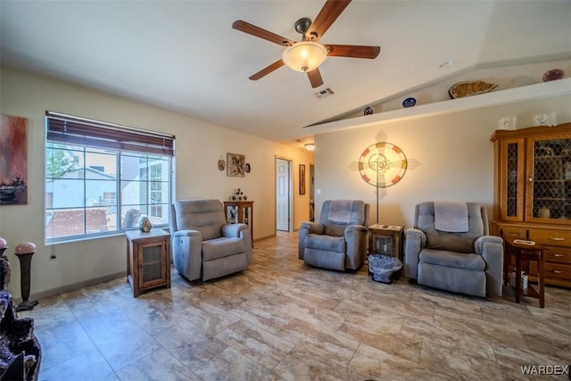 living area featuring a ceiling fan, visible vents, vaulted ceiling, and baseboards