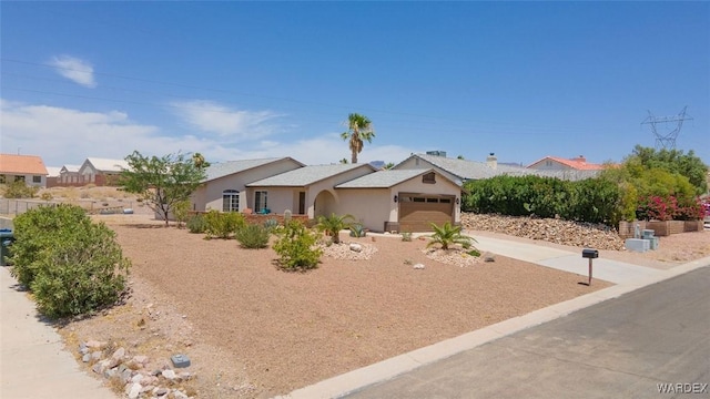 ranch-style home featuring driveway, an attached garage, and stucco siding