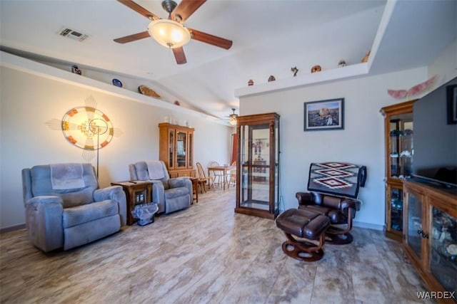 living area with visible vents, vaulted ceiling, and a ceiling fan