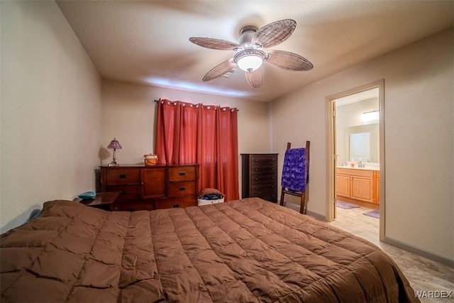 bedroom featuring ensuite bath, baseboards, and ceiling fan