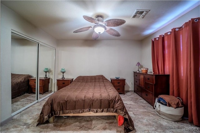 bedroom with ceiling fan, visible vents, and a closet