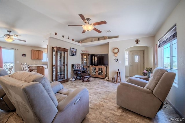 living room with ceiling fan, vaulted ceiling, visible vents, and arched walkways