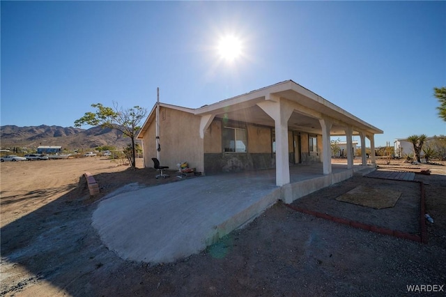 view of side of property with a mountain view and stucco siding