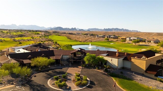 drone / aerial view featuring view of golf course, a residential view, and a water and mountain view