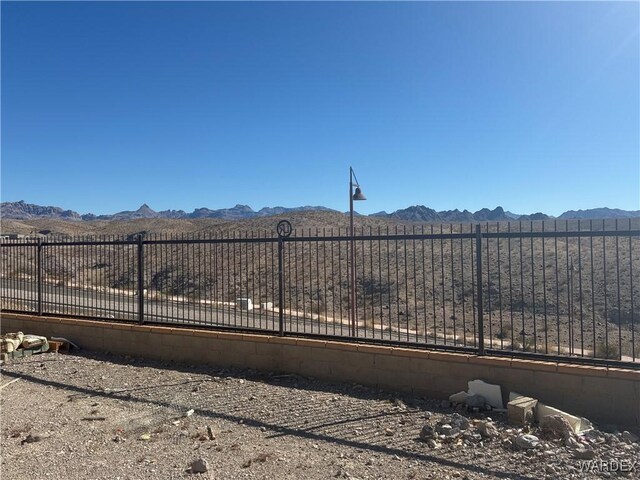 view of gate featuring fence and a mountain view