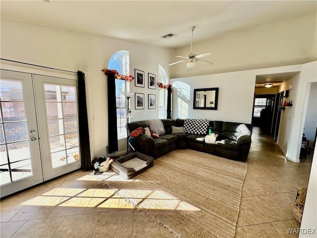 living area featuring french doors, visible vents, a high ceiling, light tile patterned flooring, and ceiling fan