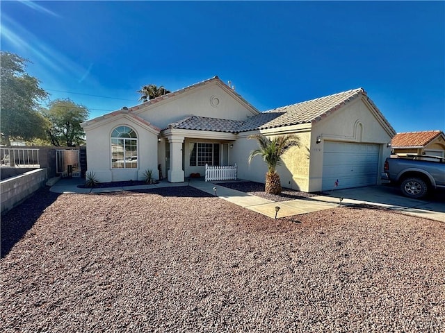 view of front of property featuring stucco siding, fence, a garage, driveway, and a tiled roof