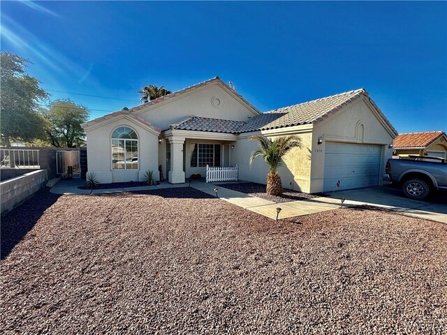 view of front of property featuring stucco siding, fence, a garage, driveway, and a tiled roof