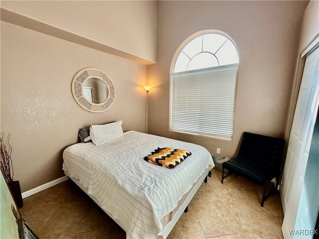 bedroom featuring baseboards and light tile patterned floors