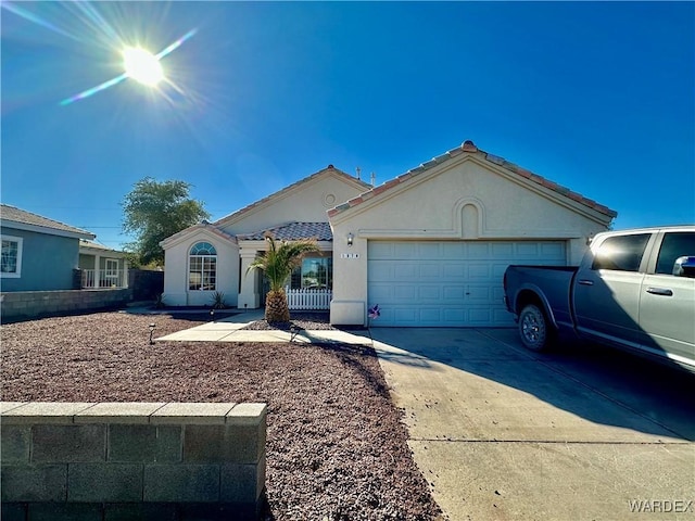 view of front facade featuring concrete driveway, an attached garage, and stucco siding