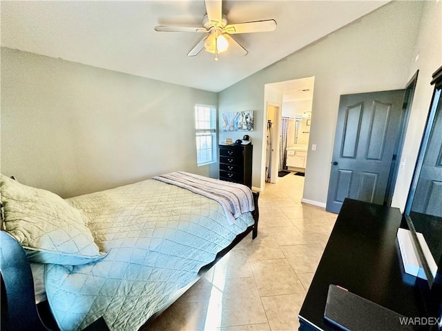 bedroom featuring lofted ceiling, light tile patterned flooring, ceiling fan, ensuite bath, and baseboards