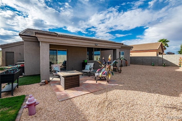 back of house with an outdoor fire pit, fence, a patio, and stucco siding