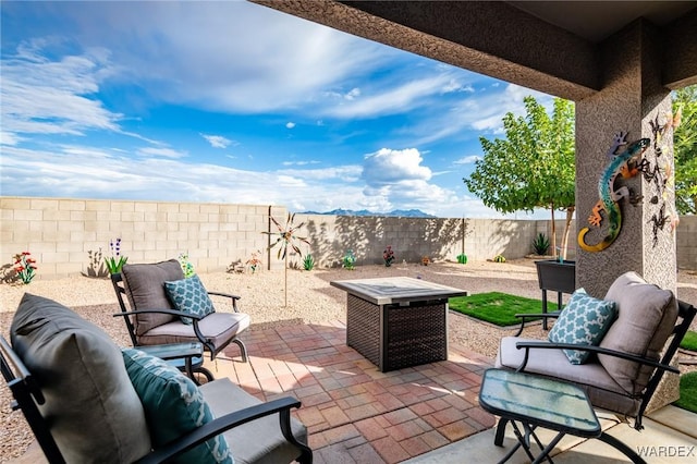 view of patio with an outdoor living space with a fire pit and a fenced backyard