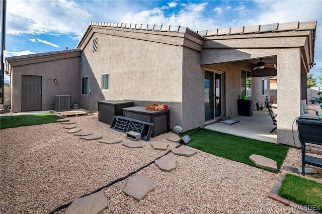 back of property with a ceiling fan, a patio, central AC unit, and stucco siding