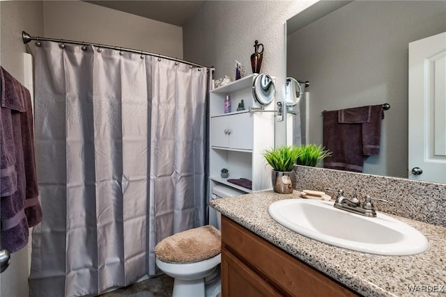 full bathroom featuring toilet, a textured wall, a shower with curtain, and vanity