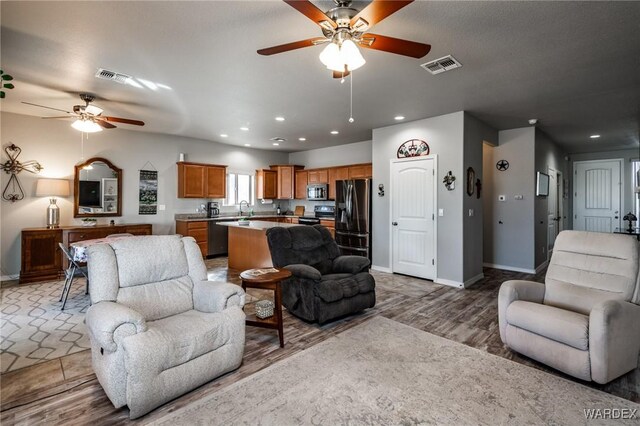 living area featuring recessed lighting, visible vents, and baseboards