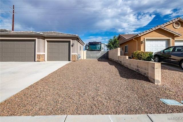 view of property exterior featuring driveway, a tile roof, an attached garage, fence, and stucco siding