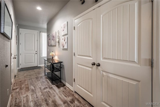 hallway featuring light wood-type flooring and baseboards