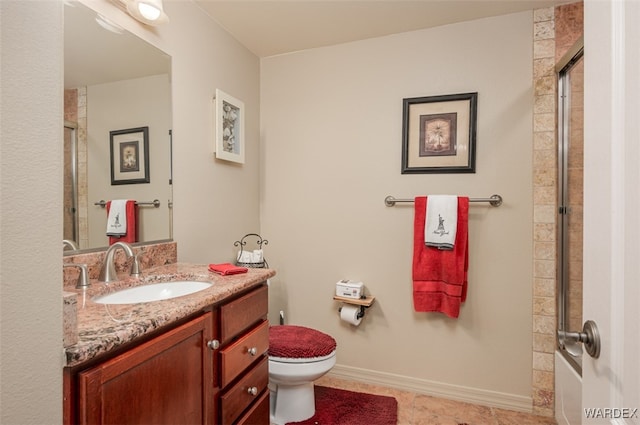 bathroom with vanity, toilet, baseboards, and a shower with door