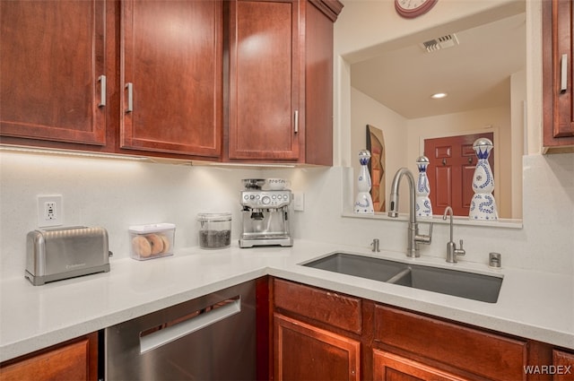 kitchen featuring a sink, visible vents, stainless steel dishwasher, and light countertops