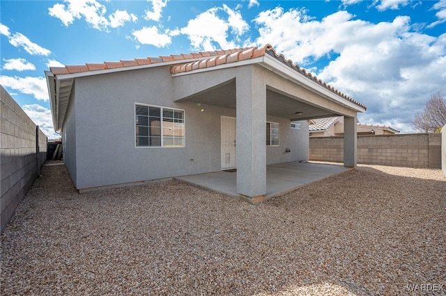 rear view of property featuring a patio area, a fenced backyard, and stucco siding