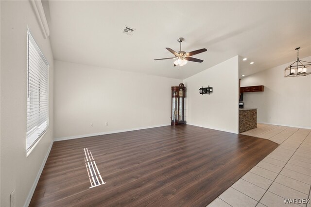 unfurnished living room with visible vents, lofted ceiling, wood finished floors, ceiling fan with notable chandelier, and recessed lighting