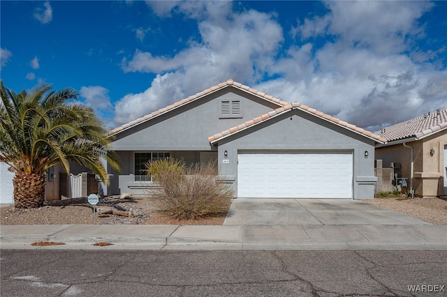 ranch-style house with an attached garage, a tiled roof, concrete driveway, and stucco siding