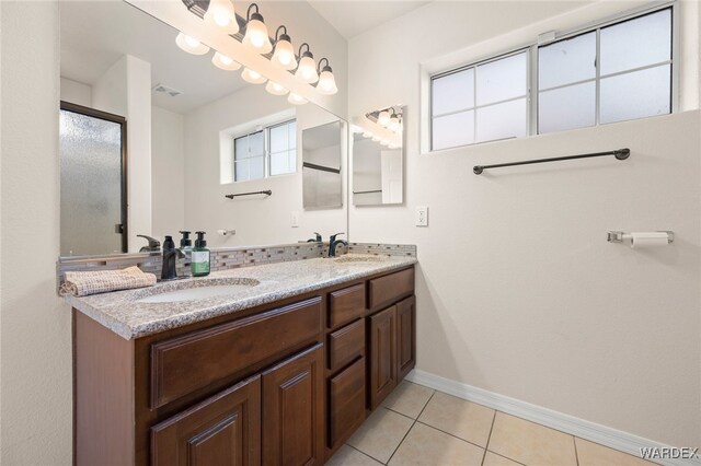 full bath featuring tile patterned flooring, visible vents, a sink, and baseboards