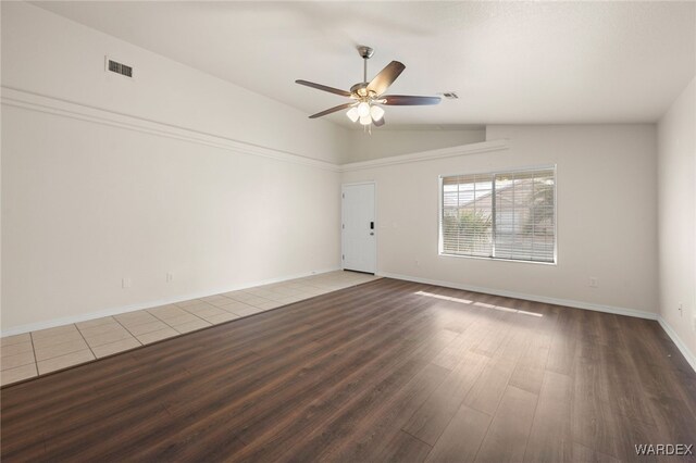 spare room featuring lofted ceiling, ceiling fan, visible vents, and wood finished floors