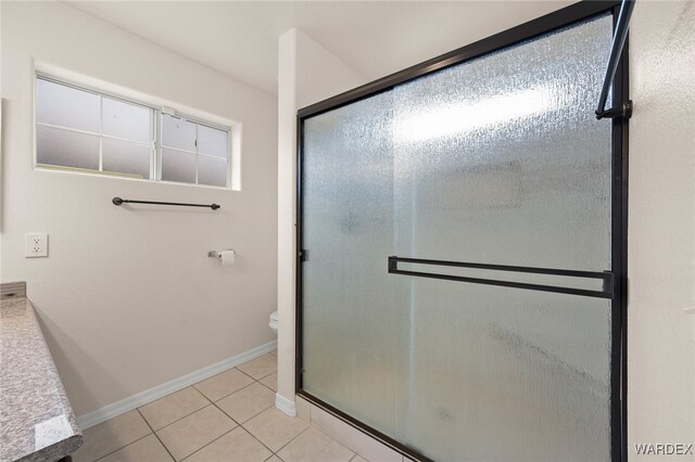 full bath featuring baseboards, tile patterned flooring, toilet, and a shower stall