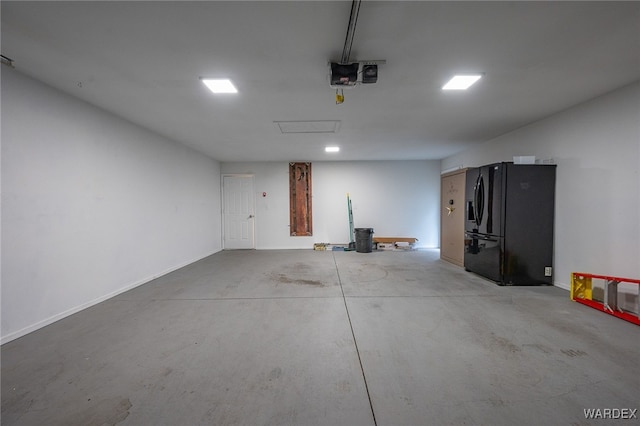 garage with a garage door opener and freestanding refrigerator