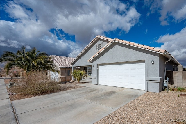 view of front of home with concrete driveway, a tiled roof, an attached garage, fence, and stucco siding