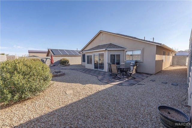 rear view of house featuring a patio, stucco siding, and a fenced backyard