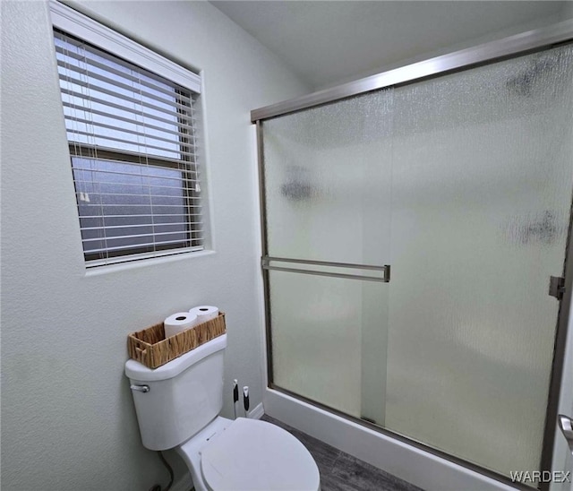 full bathroom featuring a shower stall and toilet