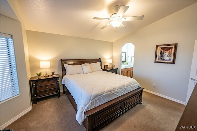 bedroom with arched walkways, carpet, baseboards, and vaulted ceiling