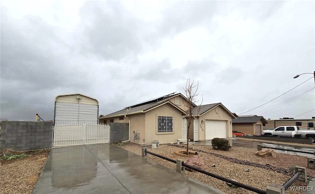 single story home with an attached garage, fence, stucco siding, driveway, and a gate