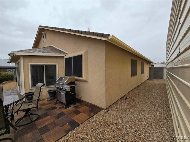 back of property with stucco siding, a patio, and fence