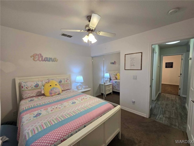 carpeted bedroom featuring baseboards, visible vents, a closet, and ceiling fan