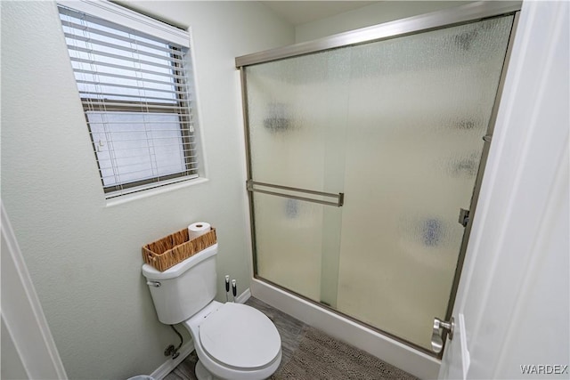 full bath with a shower stall, baseboards, and toilet