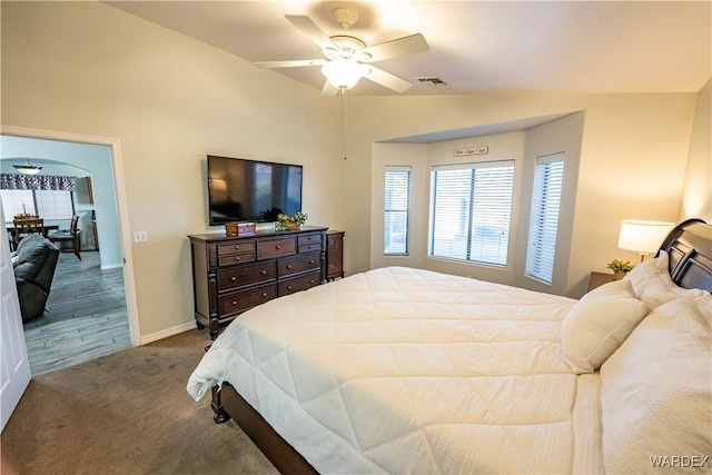 bedroom featuring baseboards, vaulted ceiling, a ceiling fan, carpet floors, and visible vents