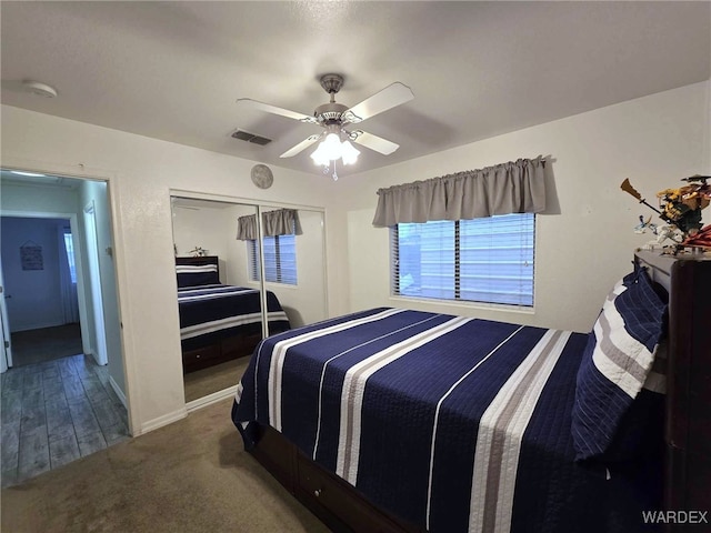 bedroom with baseboards, visible vents, ceiling fan, a closet, and carpet flooring