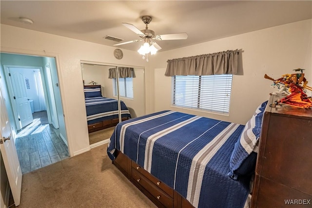 carpeted bedroom with visible vents, a ceiling fan, and a closet
