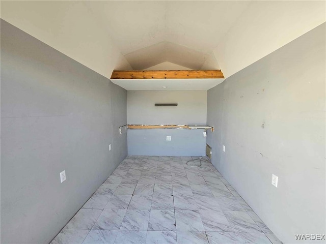 spare room with marble finish floor and lofted ceiling