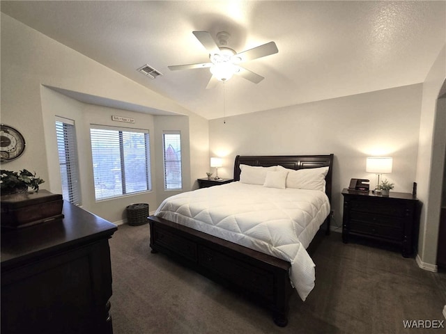 bedroom featuring visible vents, ceiling fan, baseboards, dark carpet, and vaulted ceiling