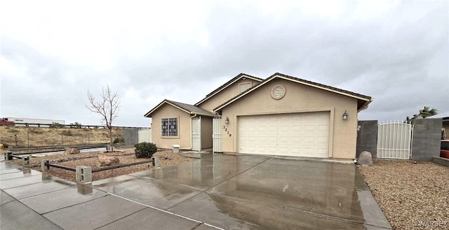 ranch-style home with a gate, fence, stucco siding, concrete driveway, and a garage