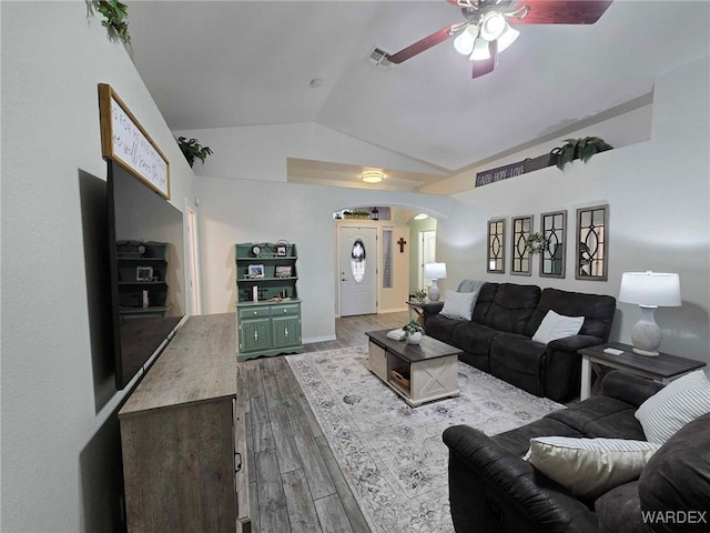 living room featuring visible vents, arched walkways, lofted ceiling, ceiling fan, and dark wood-style flooring