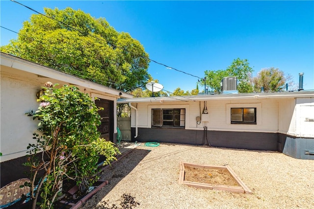 rear view of property featuring central air condition unit and a garage