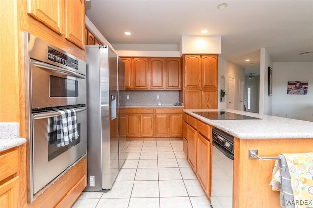 kitchen featuring light tile patterned floors, a kitchen island, recessed lighting, stainless steel appliances, and backsplash